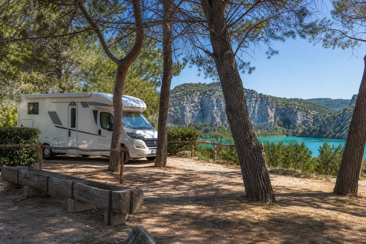 Camping-car stationné à l&rsquo;ombre de pins sur un terrain de camping provençal