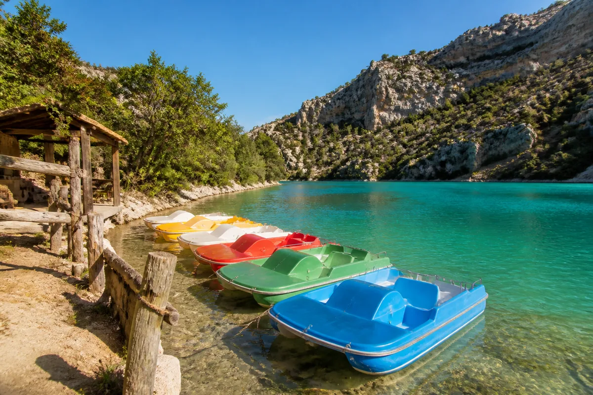 Pédalos colorés amarrés le long d’une berge du lac de Sainte-Croix